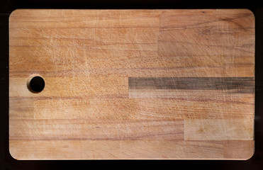 Large empty wooden cutting board with notches - kitchen tool on black background