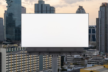 Obraz premium Blank white road billboard with Bangkok cityscape background at sunset. Street advertising poster, mock up, 3D rendering. Front view. The concept of marketing communication to promote or sell idea.