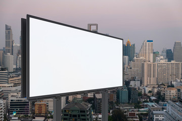 Blank white road billboard with Bangkok cityscape background at sunset. Street advertising poster, mock up, 3D rendering. Side view. The concept of marketing communication to promote or sell idea.