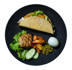 Top view taco with with fried chicken meat and vegetables and ingredients on the black plate isolated