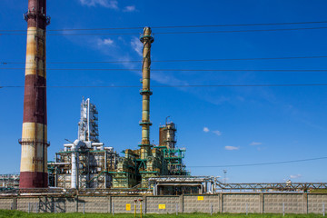 Fototapeta premium an oil refinery with industrial structures outdoors against a blue sky and space for copying in Yaroslavl Russia