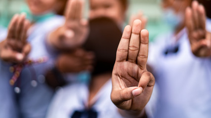 Students girl showing three finger salute in school.16:9 style