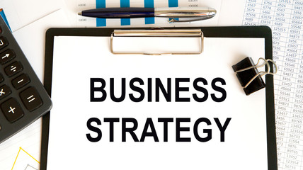 Wooden picture frame with inscription 'business strategy' on beautiful background from dollar bills...