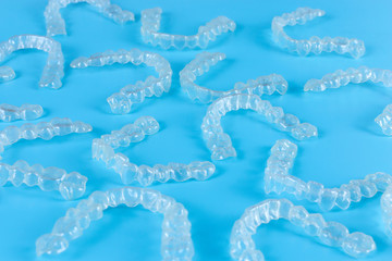 Invisalign transparent brackets or braces on blue background