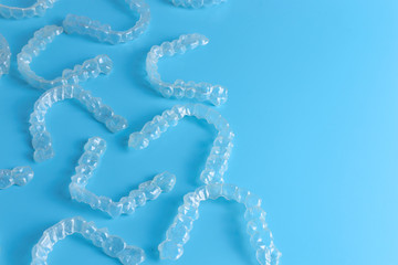 Invisalign transparent brackets or braces on blue background with copy space