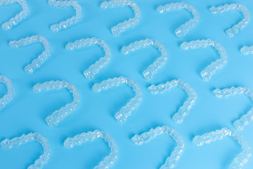 Invisalign transparent braces or brackets pattern on blue background