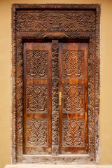 Brown traditional wooden carved Zanzibar doors in Stone Town, artwork of swahili culture, well preserved and renovated. 