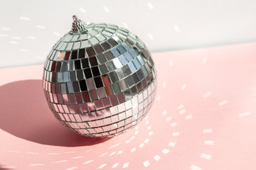 Shining disco ball on pink background. Disco ball with bright rays