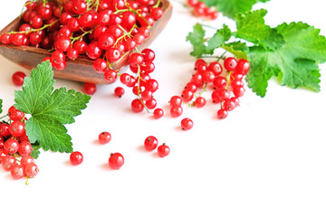 fresh red currant in a wooden bowl isolated on white background. summer harvest of vitamins.
