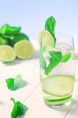 High glass of a drink with lime, ice cubes and mint for the summer