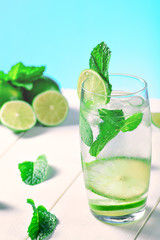High glass of a drink with lime, ice cubes and mint for the summer