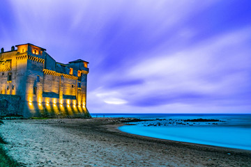 lunga esposizione al tramonto del castello di santa severa, con la spiaggia in primo piano 