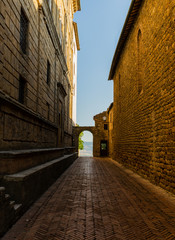 vista di un vicolo di pienza che affaccia sul panorama collinare della val d'orcia