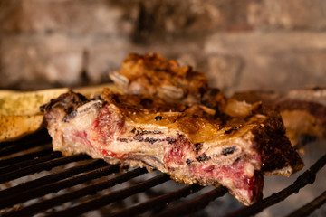 Carne cocinandose a las brasas.