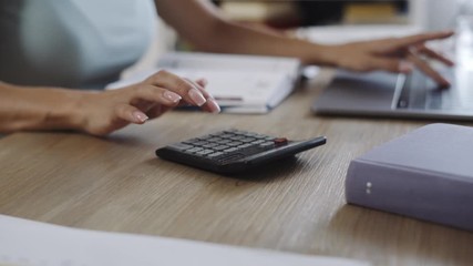 Close up of Woman Accountant's Hands Working on Laptop, Typing, Using Calculator to Check Data. Businesswoman Working from Home