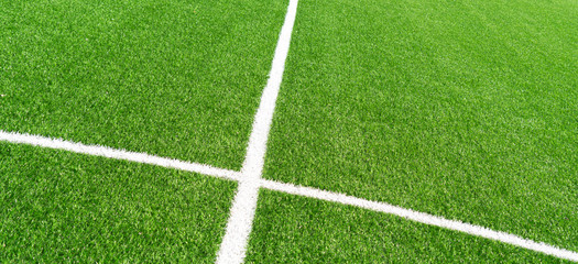 Fototapeta premium Green artificial grass turf soccer football field background with white lines. Top view