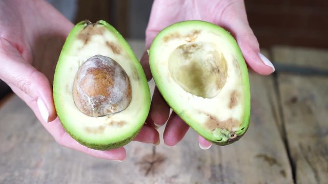 fruit of green fresh ripe avocado cut on a wooden table
