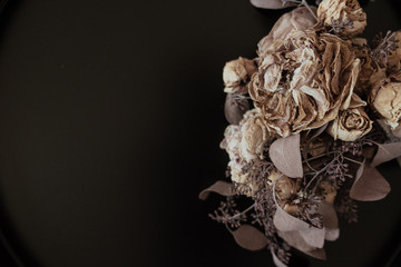 Bouquet of dried flowers on the right side and black background.