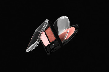 Flying makeup professional products for face on black background. Creative composition with pink...