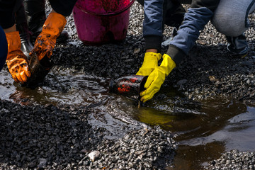 Volunteers clean the ocean coast from oil after a tanker wreck. Mauritius