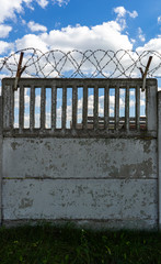 barbed wire on the fence against the blue sky.