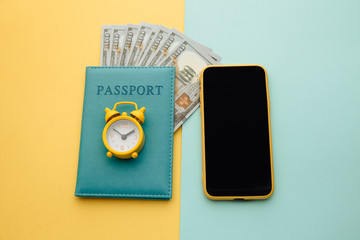 Travel planning with smartphone and passport with money on colorful background.