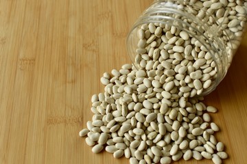 white kidney beans poured down from jar