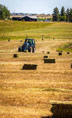 Fototapeta na wymiar An Image of a Farm Tractor Making Hay Bales in the Field