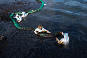 Volunteers clean the ocean coast from oil after a tanker wreck. Mauritius