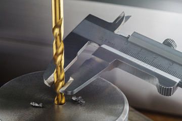 metal drill bit make holes in steel billet on industrial drilling machine. Metal work industry....
