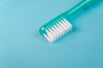 Green toothbrush on the blue background