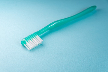 Green toothbrush on the blue background