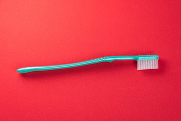 Green toothbrush on the red background