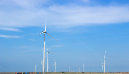 Fototapeta premium Wind turbines are installed in the steppe on a background of blue sky