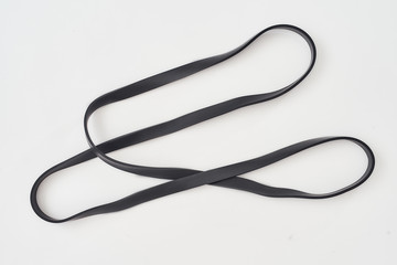 Exercising with elastic expander. Black resistance band for fitness isolated on grey background....
