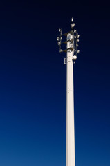 Obraz premium White steel cell phone communications tower against a blue sky