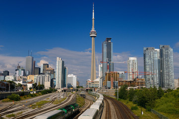 GO trains leaving on rail corridor from downtown Toronto highrise towers