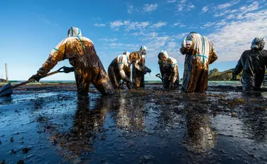 Fototapete Schiffswrack Volunteers clean the ocean coast from oil after a tanker wreck. Mauritius