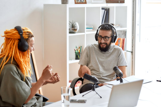 Male blogger, man in headphones listening to woman while talking, recording conversation, interview with her for video blog