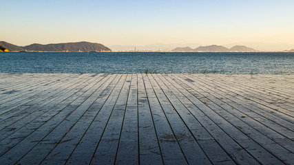 Fototapeta na wymiar View towards the sea from the wooden deck on the shore of Naoshima Island, Japan.