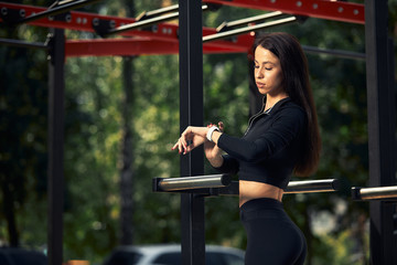 Photo of young european woman on a street workout in sports park on sunny day. Concept of training outdoor.