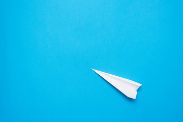 White paper plane on the blue background.