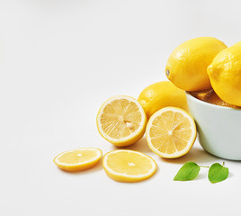 Lemons background. Group of lemons with leaves on white background. Citruses and vitamins. Creative layout made of lemon and leaves. Flat lay. Food concept. Vegetarianism and veganism. Summer