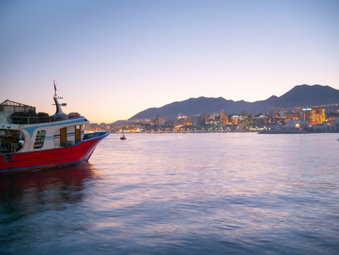 Bonito barco parado en el puerto listo para zarpar en el lindo atardecer.