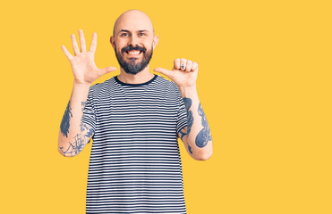Naklejka premium Young handsome man wearing casual clothes showing and pointing up with fingers number six while smiling confident and happy.