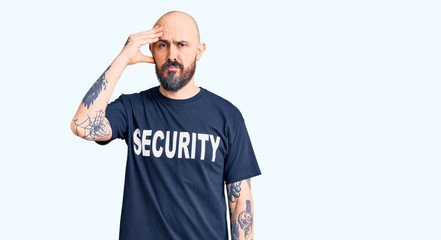 Young handsome man wearing security t shirt worried and stressed about a problem with hand on forehead, nervous and anxious for crisis