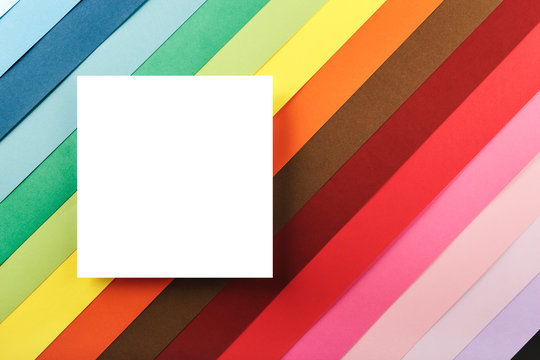 White square on a background of many colored cardboards. Handmade. Creative crafts. Copy space for text or image. Template or mockup.