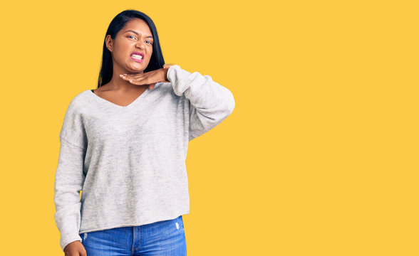 Hispanic woman with long hair wearing casual clothes cutting throat with hand as knife, threaten aggression with furious violence