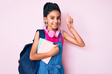 Young african american girl child with braids holding student backpack and books surprised with an idea or question pointing finger with happy face, number one