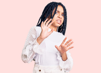 Cute african american girl wearing casual white tshirt disgusted expression, displeased and fearful...